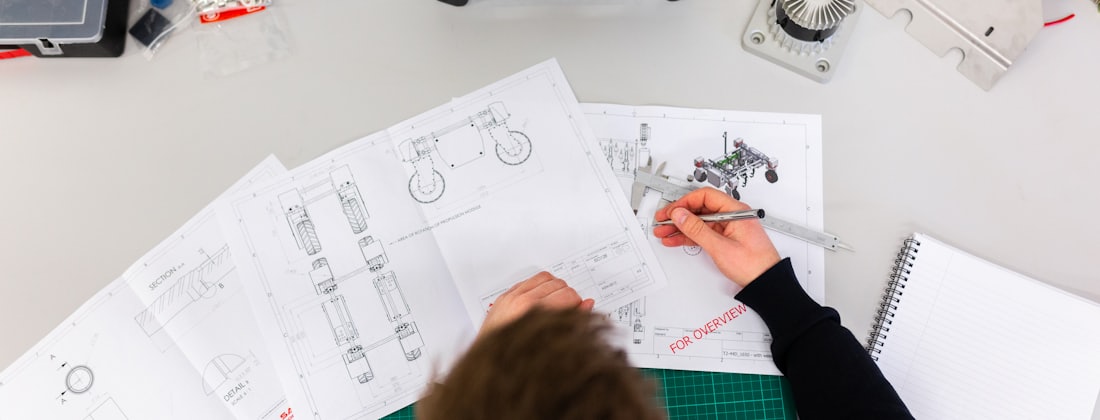 Technical drawings and callipers laid out on a desk