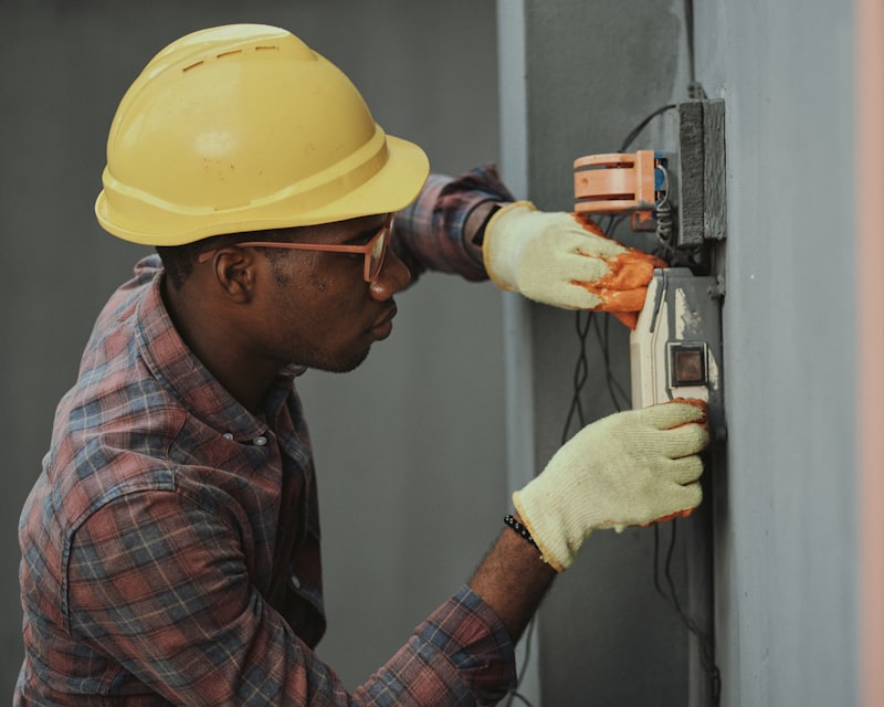 A tradesperson working on site with both hands busy
