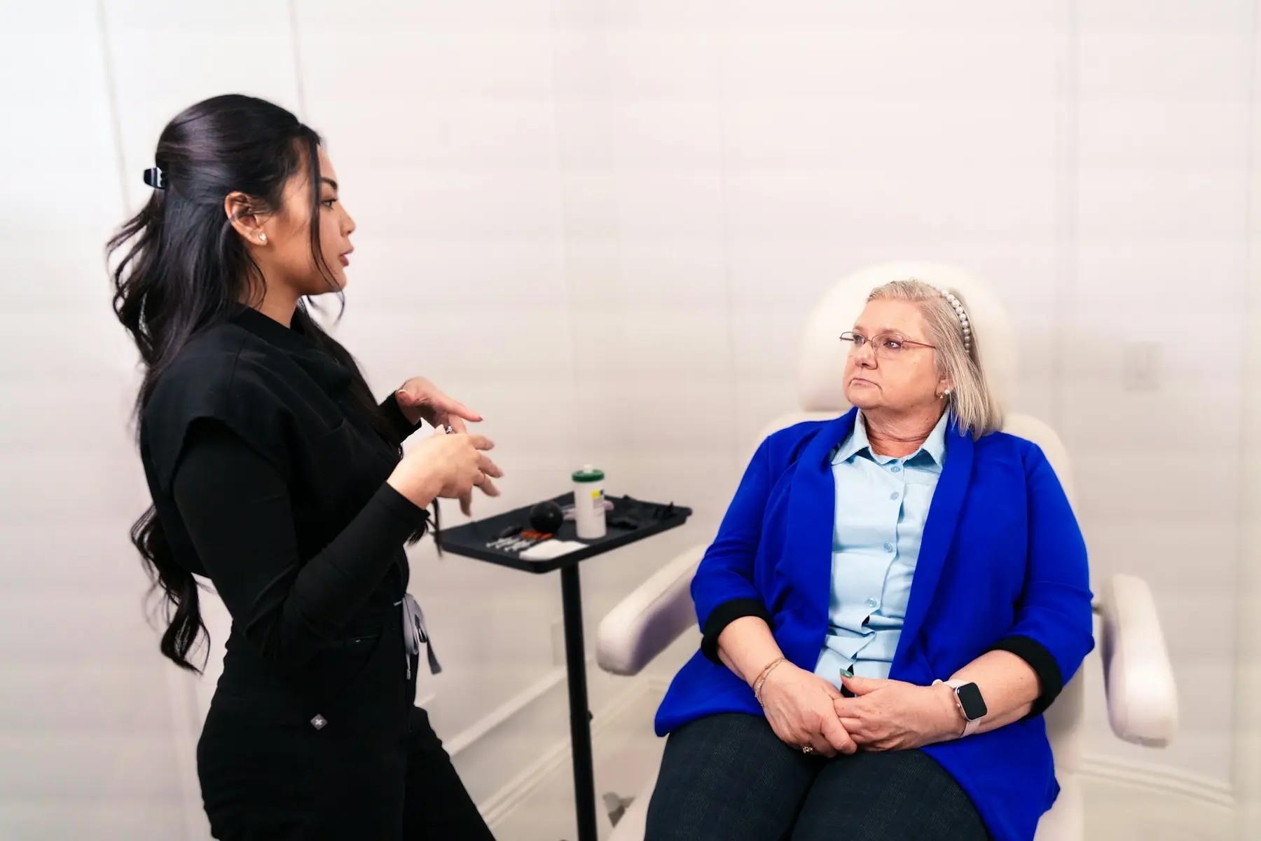 A practitioner talking a client through her options in a treatment room