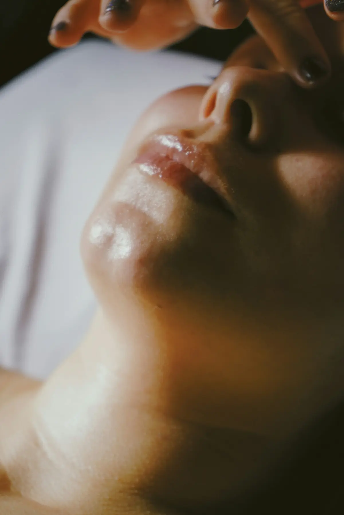 Close-up of a woman's lips and jaw in warm light